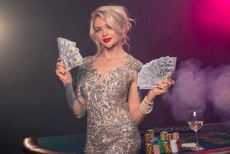De blondevrouw met een mooi kapsel en een perfecte samenstelling stelt met wat geld in haar handen Casino, pook royalty-vrije stock afbeelding De blondevrouw met een mooi kapsel en een perfecte samenstelling stelt met wat geld in haar handen Casino, pook royalty-vrije stock afbeelding