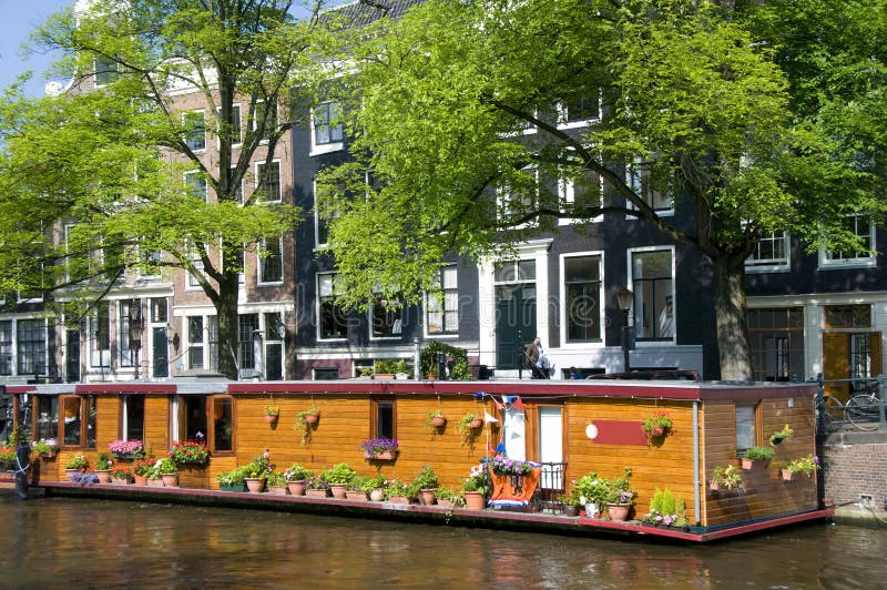 De boot van het het kanaalhuis van Amsterdam Holland met bloemen