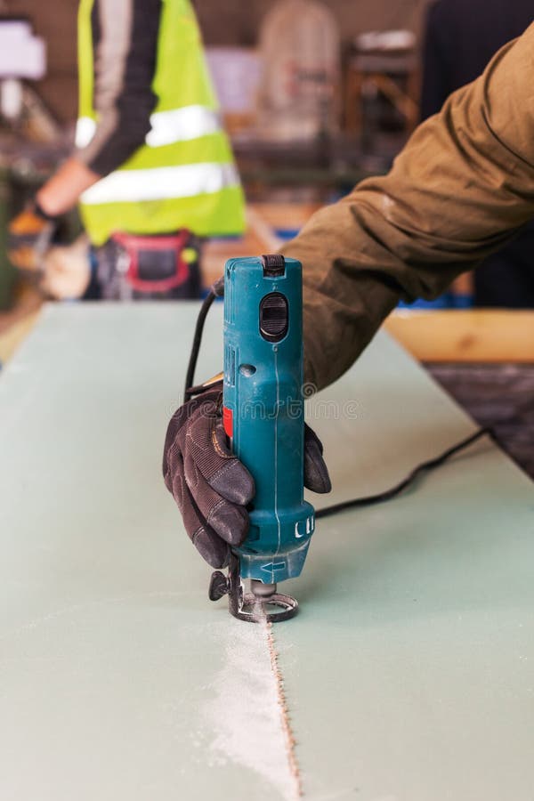 De bouw van een muur voor kaderhuis De Gelamineerde Snoeischaar van het arbeidersgebruik voor scherpe drywall royalty-vrije stock fotografie De bouw van een muur voor kaderhuis De Gelamineerde Snoeischaar van het arbeidersgebruik voor scherpe drywall royalty-vrije stock fotografie