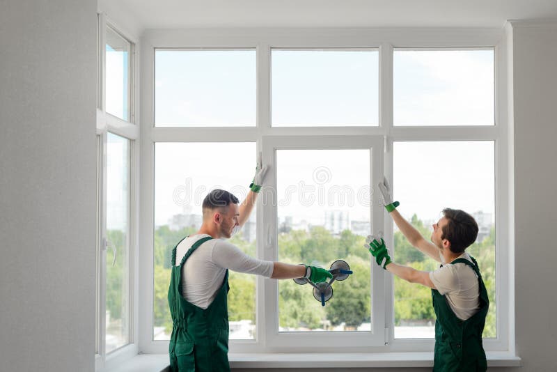 De bouwvakkers installeren een venster stock fotografie De bouwvakkers installeren een venster stock fotografie