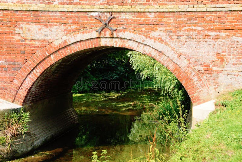 De Brug Van De Baksteenboog Over Rivier Stock Foto - Image of rood