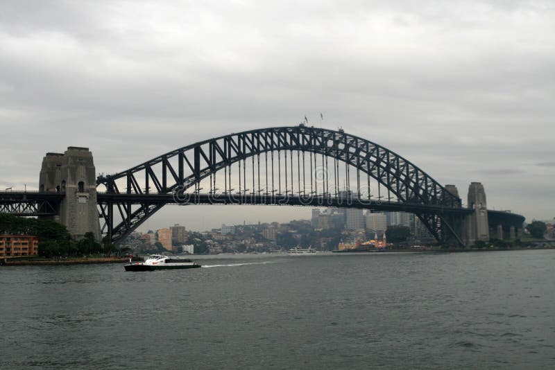 The Sydney Harbour Bridge is a steel arch bridge across Sydney Harbour that carries rail, vehicular and pedestrian traffic between the Sydney central business district (CBD) and the North Shore. The dramatic view of the bridge, the harbour, and the nearby Sydney Opera House is an iconic image of both Sydney and Australia. The bridge is locally nicknamed The Coathangeror Colin because of its arch-based design. The bridge was designed and built by Christina Dorman Long and Co Ltd and opened in 1932. Until 1967 it was the city's tallest structure. According to Guinness World Records, it is the world's widest long-span bridge and its tallest steel arch bridge, measuring 134 metres (429.6 ft) from top to water level. It is also the fourth-longest spanning-arch bridge in the world. The southern (CBD) bridge end is located at Millers Point in The Rocks area, and the northern end at Milsons Point in the lower North Shore area. It carries six lanes of road traffic on its main roadway, two lanes of road traffic (formerly two tram tracks) and a footpath on its eastern side, and two railway tracks and a bicycle path along its western side, being 305 mm (1 ft) larger than the east side. The road across the bridge is known as Bradfield Highway, Sydney, and is about 2.4 km (1.5 miles) long, making it one of the shortest highways in Australia. (The shortest, also called the Bradfield Highway, is found on the Story Bridge in Brisbane). The Sydney Harbour Bridge is a steel arch bridge across Sydney Harbour that carries rail, vehicular and pedestrian traffic between the Sydney central business district (CBD) and the North Shore. The dramatic view of the bridge, the harbour, and the nearby Sydney Opera House is an iconic image of both Sydney and Australia. The bridge is locally nicknamed The Coathangeror Colin because of its arch-based design. The bridge was designed and built by Christina Dorman Long and Co Ltd and opened in 1932. Until 1967 it was the city's tallest structure. According to Guinness World Records, it is the world's widest long-span bridge and its tallest steel arch bridge, measuring 134 metres (429.6 ft) from top to water level. It is also the fourth-longest spanning-arch bridge in the world. The southern (CBD) bridge end is located at Millers Point in The Rocks area, and the northern end at Milsons Point in the lower North Shore area. It carries six lanes of road traffic on its main roadway, two lanes of road traffic (formerly two tram tracks) and a footpath on its eastern side, and two railway tracks and a bicycle path along its western side, being 305 mm (1 ft) larger than the east side. The road across the bridge is known as Bradfield Highway, Sydney, and is about 2.4 km (1.5 miles) long, making it one of the shortest highways in Australia. (The shortest, also called the Bradfield Highway, is found on the Story Bridge in Brisbane).