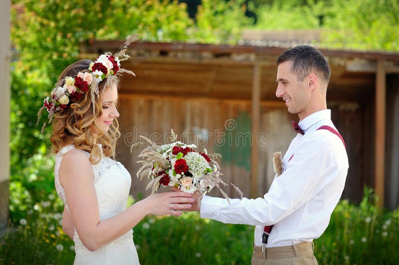De bruidegom geeft het boeket van het bruidhuwelijk stock fotografie De bruidegom geeft het boeket van het bruidhuwelijk stock fotografie