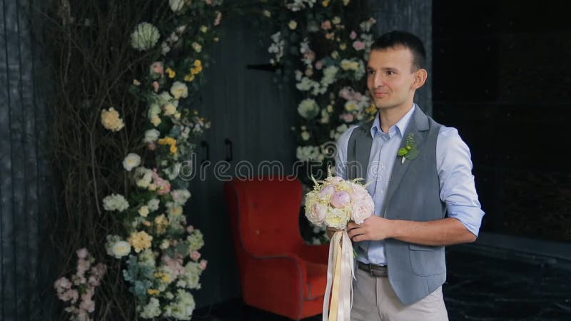De bruidegom wacht op bruid om haar huwelijksboeket te overhandigen