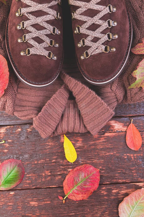 De bruine laarzen van het mensensuède met sweater op houten achtergrond stock foto's De bruine laarzen van het mensensuède met sweater op houten achtergrond stock foto's