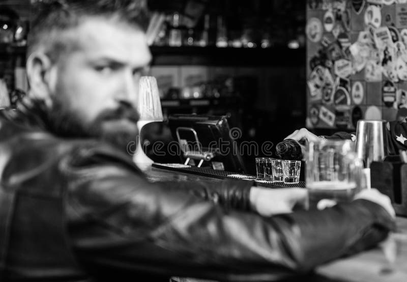 De brutale hipster gebaarde mens zit bij barteller drinkt bier Vrijdag avond De bar ontspant plaats om drank te hebben en te onts royalty-vrije stock afbeelding De brutale hipster gebaarde mens zit bij barteller drinkt bier Vrijdag avond De bar ontspant plaats om drank te hebben en te onts royalty-vrije stock afbeelding