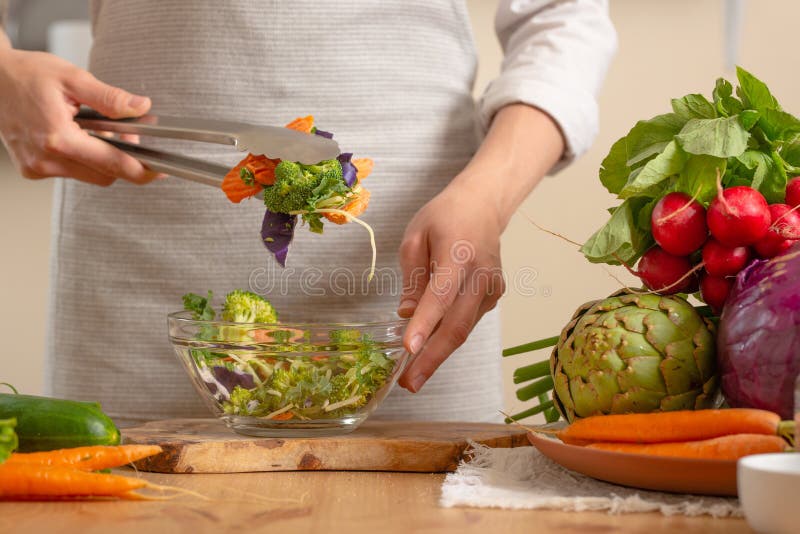 De chef-kok bereidt een vers en helder saladeclose-up, op een lichte achtergrond voor Het concept het verliezen van gezond en gez royalty-vrije stock afbeelding De chef-kok bereidt een vers en helder saladeclose-up, op een lichte achtergrond voor Het concept het verliezen van gezond en gez royalty-vrije stock afbeelding