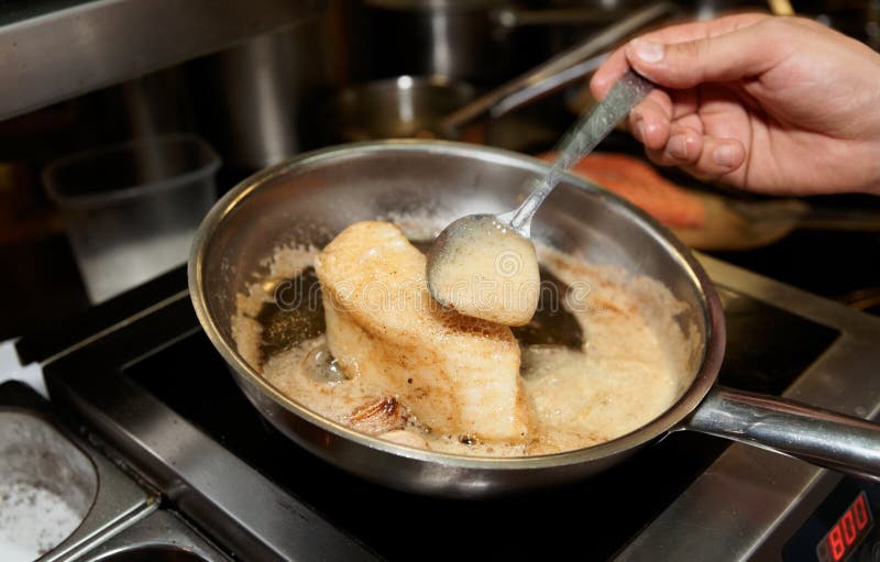 De chef bakt chilese zeebaarsfilet royalty-vrije stock fotografie