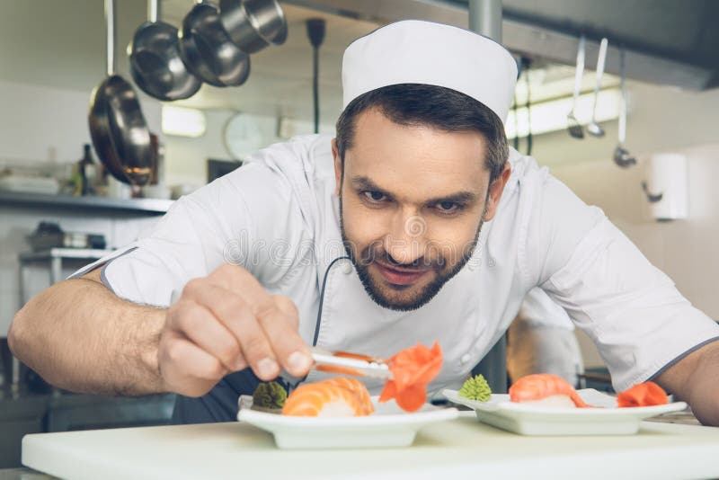 De chef-kok van het mensen het Japanse restaurant koken in de keuken stock fotografie De chef-kok van het mensen het Japanse restaurant koken in de keuken stock fotografie