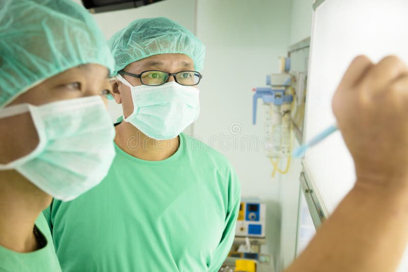 De chirurgen die verslagen schrijven en bespreken stock fotografie De chirurgen die verslagen schrijven en bespreken stock fotografie