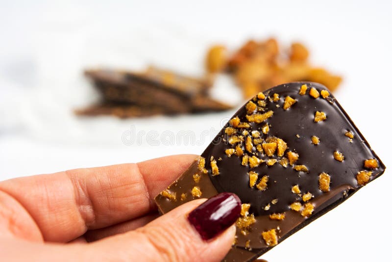 De chocolade van de handholding met amandelen stock foto De chocolade van de handholding met amandelen stock foto