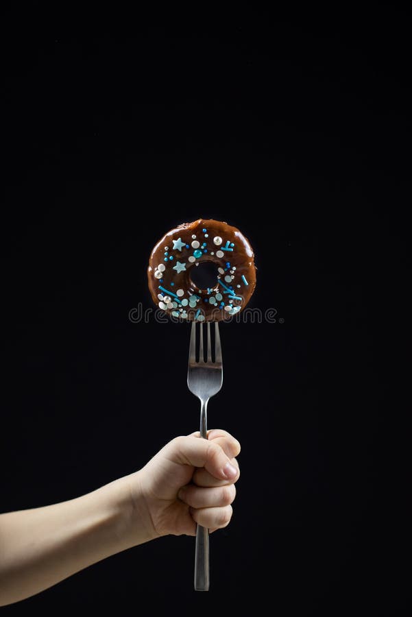 De chocoladedoughnut met vork dient zwarte achtergrond in royalty-vrije stock foto De chocoladedoughnut met vork dient zwarte achtergrond in royalty-vrije stock foto