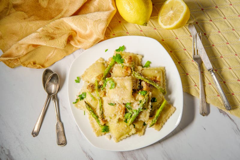 Italian cheese ravioli with oven roasted asparagus in herbed lemon butter sauce topped with parmesan and cracked black pepper. Italian cheese ravioli with oven roasted asparagus in herbed lemon butter sauce topped with parmesan and cracked black pepper