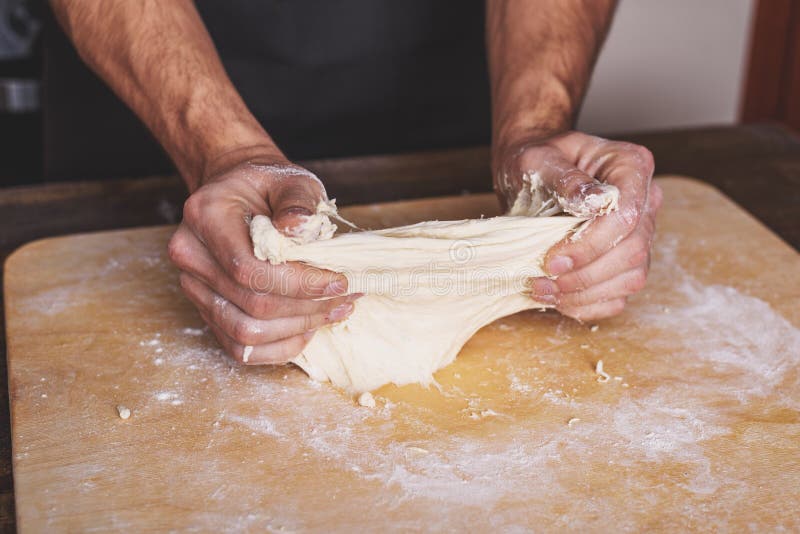 De close-up van mannelijke handen kneedt het deeg voor eigengemaakte pizza, de problemen om te koken, een incompetente chef-kok stock foto's De close-up van mannelijke handen kneedt het deeg voor eigengemaakte pizza, de problemen om te koken, een incompetente chef-kok stock foto's