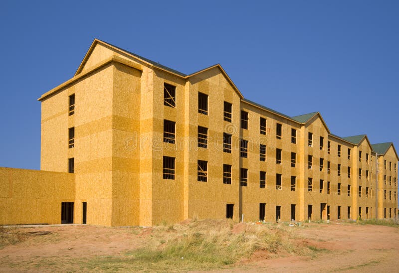 A commercial construction zone for apartments or a hotel against a blue sky background. A commercial construction zone for apartments or a hotel against a blue sky background