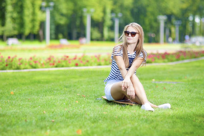 De Concepten van de tienerslevensstijl Portret van het Leuke en Positieve Kaukasische Blonde Tienermeisje Stellen op Longboard in stock afbeelding De Concepten van de tienerslevensstijl Portret van het Leuke en Positieve Kaukasische Blonde Tienermeisje Stellen op Longboard in stock afbeelding