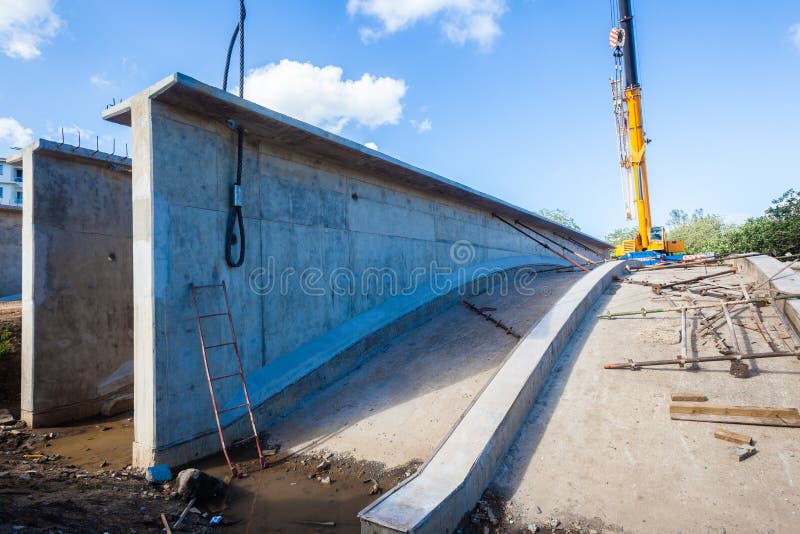 Concrete Bridge sections of fifty ton weight built next to bridge site and lifted off floor arched moulds onto large abnormal trailer trucks. Concrete Bridge sections of fifty ton weight built next to bridge site and lifted off floor arched moulds onto large abnormal trailer trucks