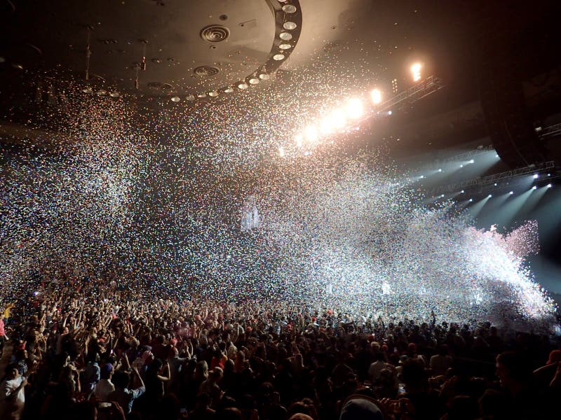 Honolulu - January 8, 2017: Confetti Flies into the air during Chance the Rapper Concert with crowd hands waving in the air. Honolulu - January 8, 2017: Confetti Flies into the air during Chance the Rapper Concert with crowd hands waving in the air.