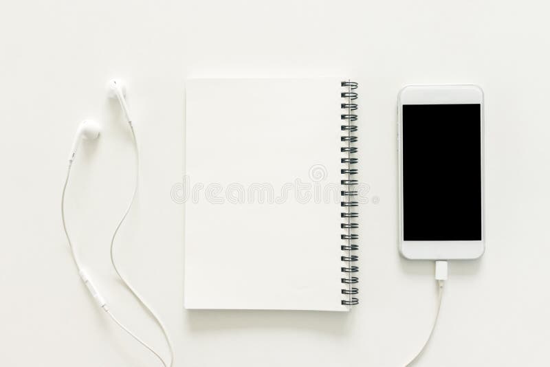 De creatieve vlakte legt foto van werkruimtebureau met sketchbook en mobiele telefoon met het lege scherm op exemplaar ruimte wit stock foto's De creatieve vlakte legt foto van werkruimtebureau met sketchbook en mobiele telefoon met het lege scherm op exemplaar ruimte wit stock foto's