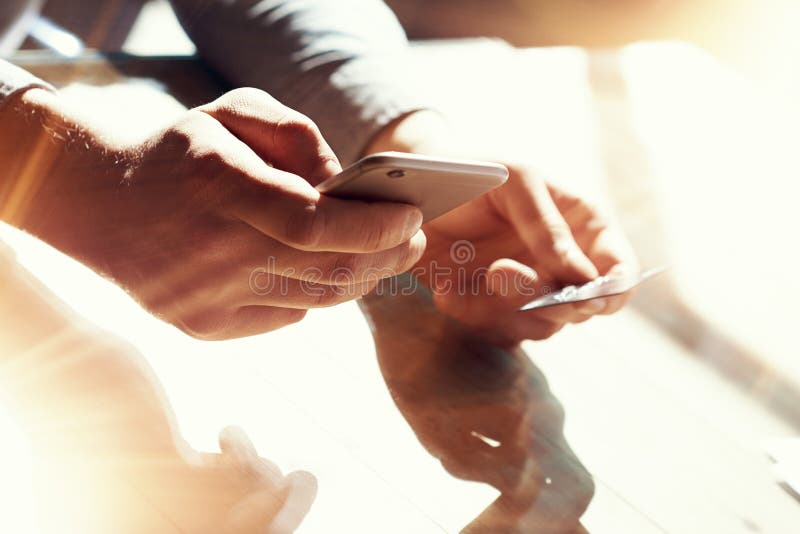 De Creditcard van de de Holdingshand van de close-upmens De Betalingen van zakenmanuse smartphone online het Winkelen Guy Touchin stock fotografie De Creditcard van de de Holdingshand van de close-upmens De Betalingen van zakenmanuse smartphone online het Winkelen Guy Touchin stock fotografie