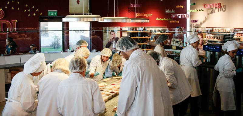 De culinaire klasse die in keuken chocolade maken als leraar overziet royalty-vrije stock foto's De culinaire klasse die in keuken chocolade maken als leraar overziet royalty-vrije stock foto's