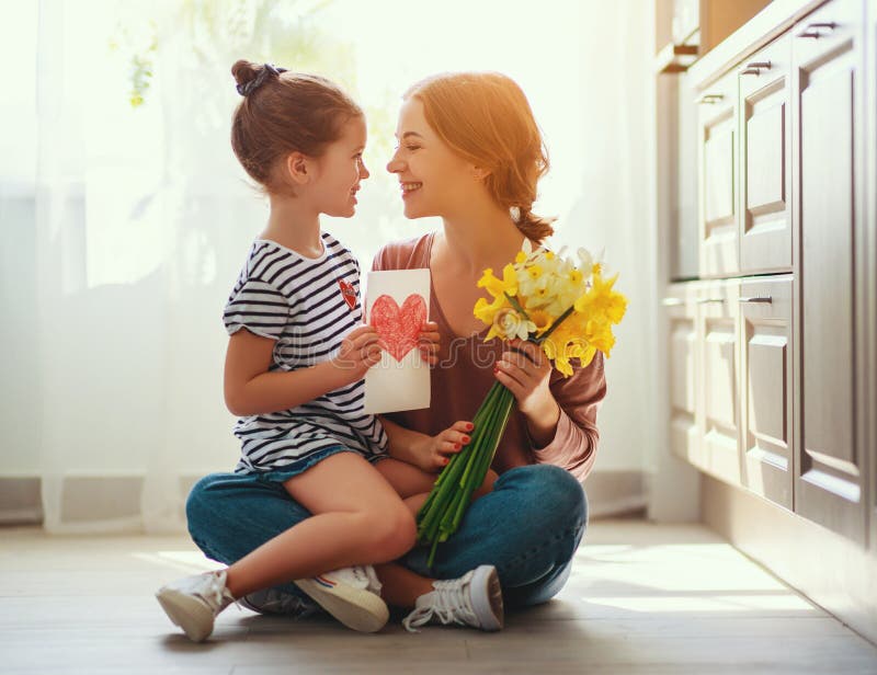 De dag van de gelukkige moeder! de kinddochter geeft moeder een boeket van bloemen aan narcissen en gift royalty-vrije stock foto's De dag van de gelukkige moeder! de kinddochter geeft moeder een boeket van bloemen aan narcissen en gift royalty-vrije stock foto's