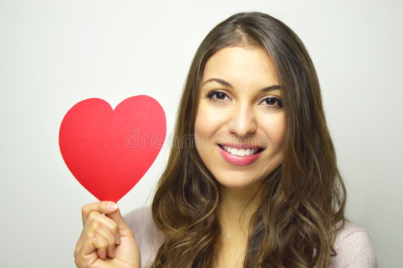 De dag van de valentijnskaart `s Mooie jonge vrouw die een een document hart en glimlach houden bij camera op grijze achtergrond stock afbeeldingen De dag van de valentijnskaart `s Mooie jonge vrouw die een een document hart en glimlach houden bij camera op grijze achtergrond stock afbeeldingen