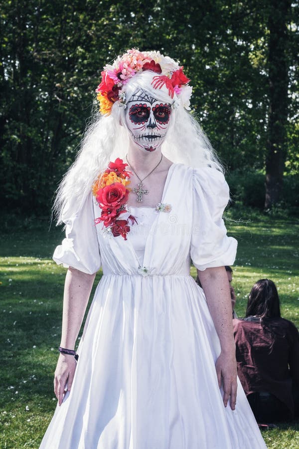 De dame in wit met een verschrikkingsgrimage stelt in het park tijdens stock fotografie De dame in wit met een verschrikkingsgrimage stelt in het park tijdens stock fotografie