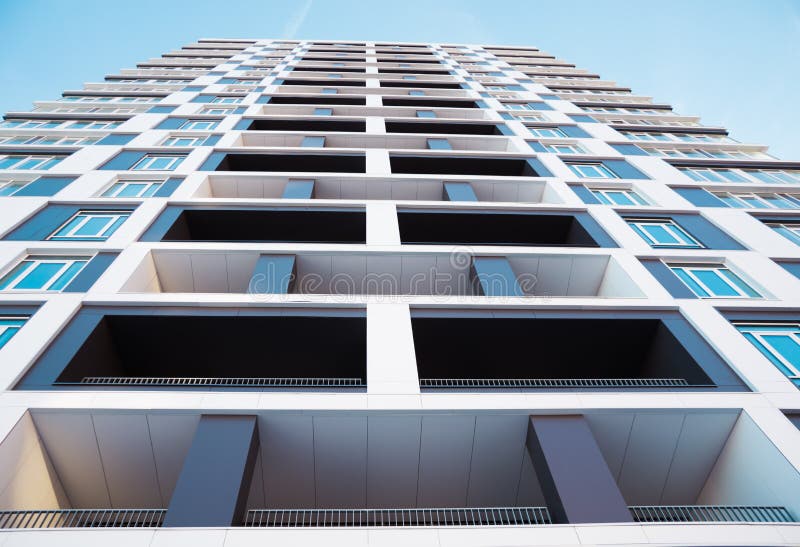 De debajo tiro de la construcción de viviendas moderna y nueva Foto de un bloque de viviendas alto con los balcones contra un cie imágenes de archivo libres de regalías De debajo tiro de la construcción de viviendas moderna y nueva Foto de un bloque de viviendas alto con los balcones contra un cie imágenes de archivo libres de regalías