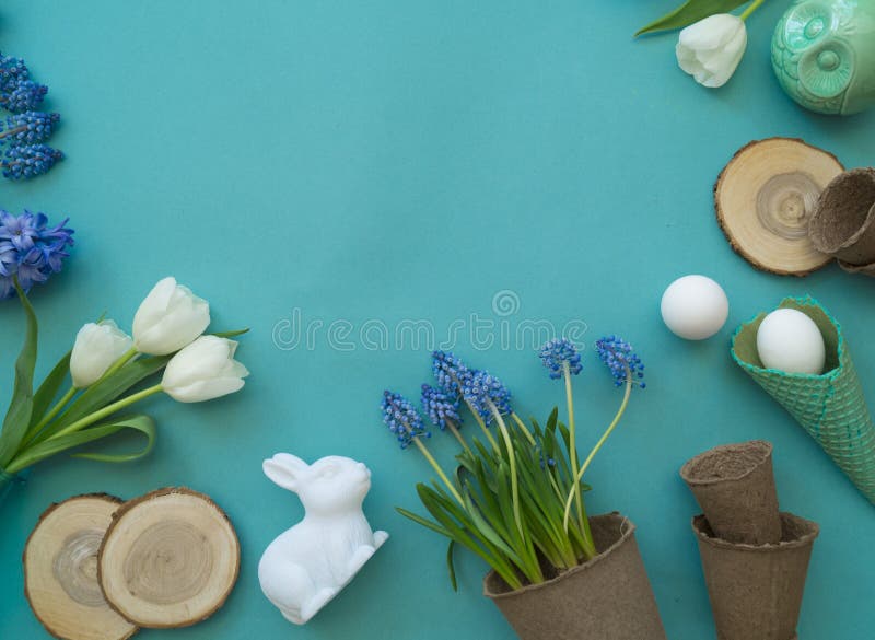 De decoratieve samenstelling van Pasen op een blauwe achtergrond Witte tulpen, bloempotten, unpainted eieren en een boom stock afbeeldingen De decoratieve samenstelling van Pasen op een blauwe achtergrond Witte tulpen, bloempotten, unpainted eieren en een boom stock afbeeldingen