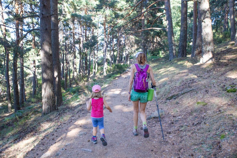 De derrière les alpinistes femme et petite fille randonnée sur sentier dans la forêt près de madrid
