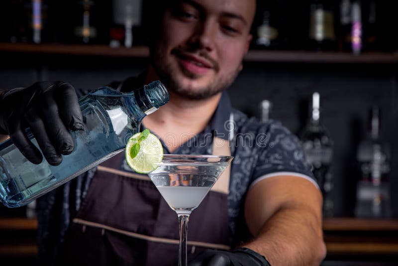 De deskundige barman maakt cocktail bij nachtclub Professionele barman aan het werk in bar die zoete drank gieten in glas stock afbeelding De deskundige barman maakt cocktail bij nachtclub Professionele barman aan het werk in bar die zoete drank gieten in glas stock afbeelding