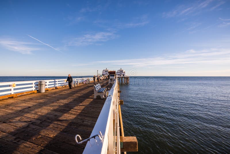 December 2, 2018 Malibu / CA / USA - Sunset view of Malibu Pier; people walking along it or fishing on a sunny day. December 2, 2018 Malibu / CA / USA - Sunset view of Malibu Pier; people walking along it or fishing on a sunny day