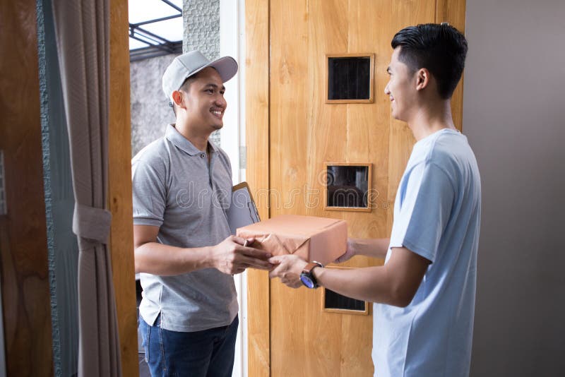 Man receiving a package at home from a delivery guy. Man receiving a package at home from a delivery guy