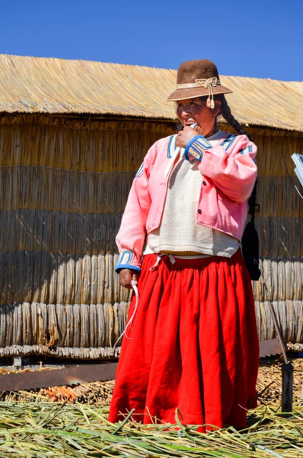DE DRIJVENDE EILANDEN VAN UROS, PUNO, PERU 31 MEI, 2013: De niet geïdentificeerde inheemse vrouw die traditionele doeken dragen e royalty-vrije stock foto DE DRIJVENDE EILANDEN VAN UROS, PUNO, PERU 31 MEI, 2013: De niet geïdentificeerde inheemse vrouw die traditionele doeken dragen e royalty-vrije stock foto