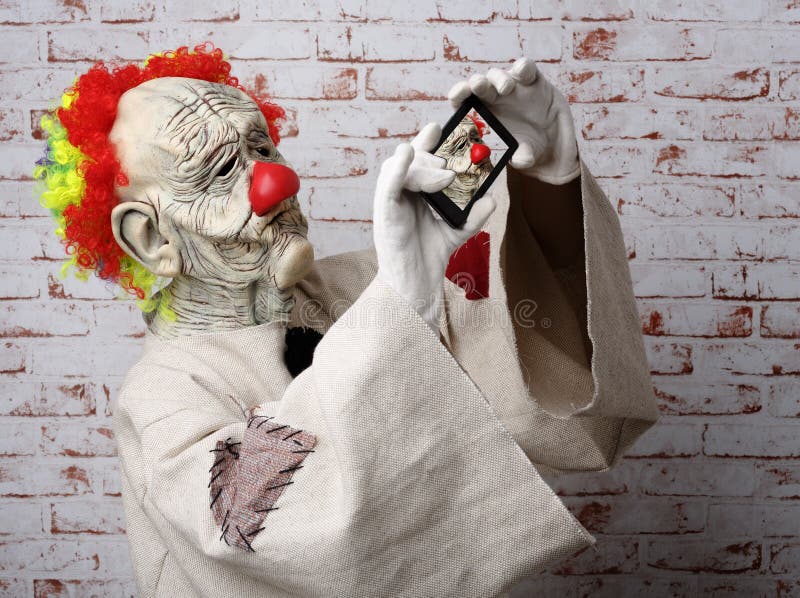 De droevige clown maakt selfie op cellphone stock afbeelding De droevige clown maakt selfie op cellphone stock afbeelding