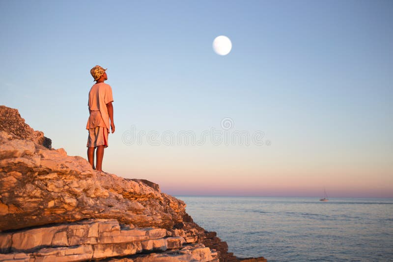 De dromerige jongen bewondert verrukte maan in de hemel