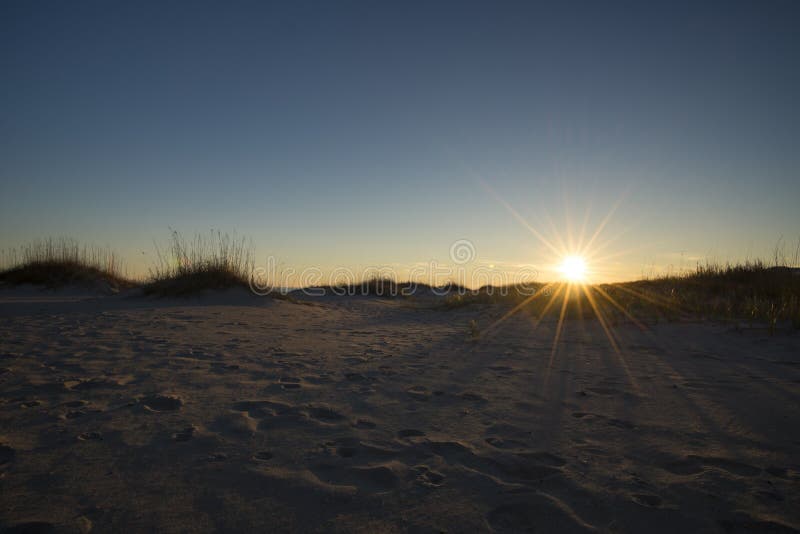 De duinen kleurrijke hemel van het kustzand bij zonsondergang stock afbeelding De duinen kleurrijke hemel van het kustzand bij zonsondergang stock afbeelding