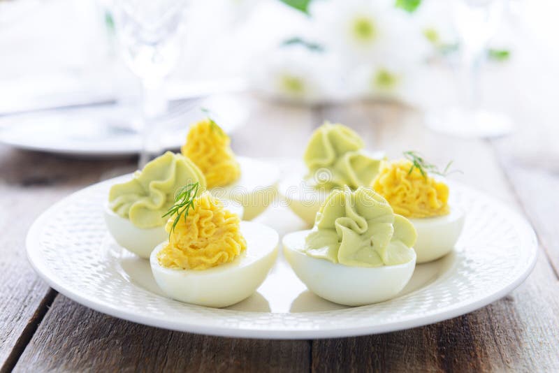 De Eieren van Pasen snack^ met kaas en avocadomousse worden gevuld die stock foto De Eieren van Pasen snack^ met kaas en avocadomousse worden gevuld die stock foto