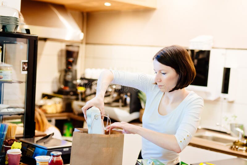 De eigenaarverpakking van de vrouwen het kleine lokale winkel winkelen stock foto De eigenaarverpakking van de vrouwen het kleine lokale winkel winkelen stock foto