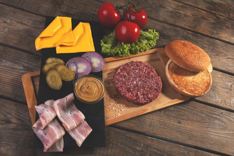 De eigengemaakte kaas van cheeseburger verse ingrediënten, broodje, zoutte komkommer, rundvleespasteitjes, bacon stock foto's De eigengemaakte kaas van cheeseburger verse ingrediënten, broodje, zoutte komkommer, rundvleespasteitjes, bacon stock foto's