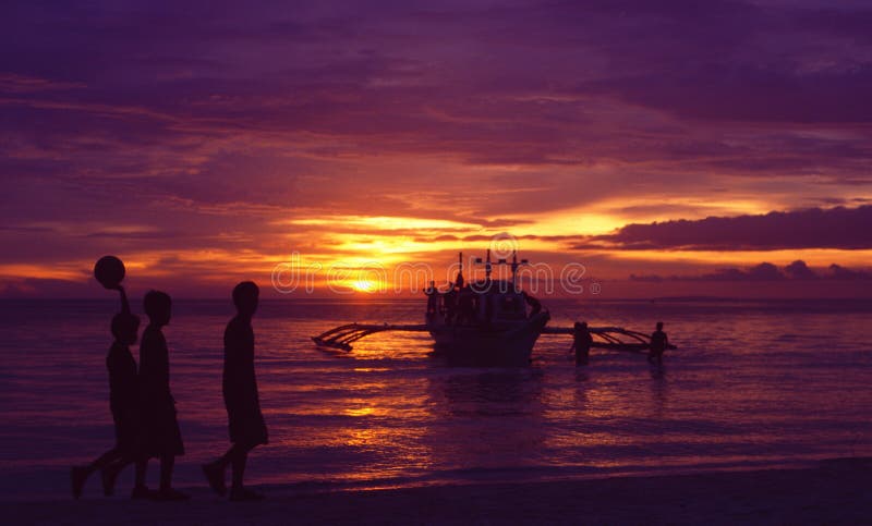 De Eilanden van Filippijnen: Drie jongens bij zonsondergang op Boracay royalty-vrije stock afbeeldingen De Eilanden van Filippijnen: Drie jongens bij zonsondergang op Boracay royalty-vrije stock afbeeldingen
