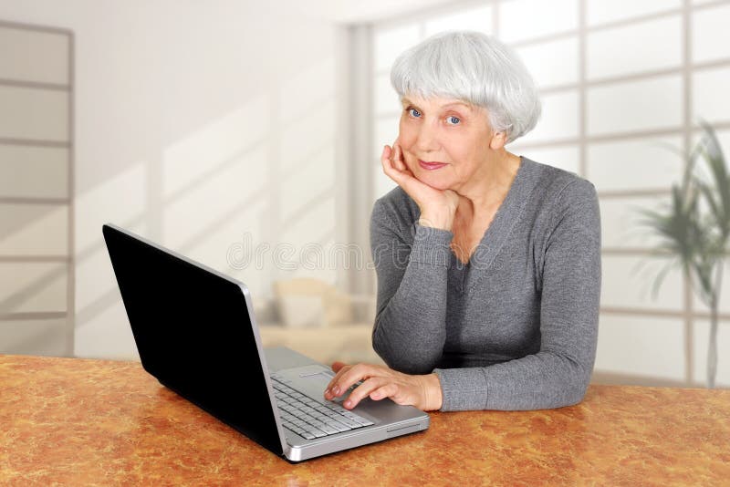 Elegant elderly senior woman using laptop computer communicates at home. Elegant elderly senior woman using laptop computer communicates at home