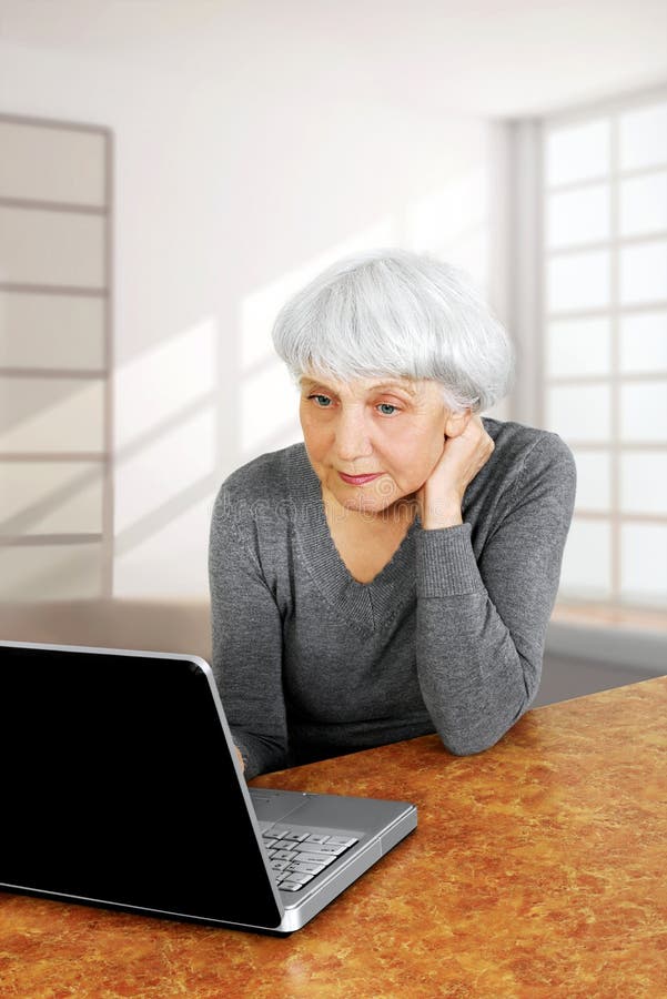 Elegant elderly senior woman using laptop computer communicates at home. Elegant elderly senior woman using laptop computer communicates at home