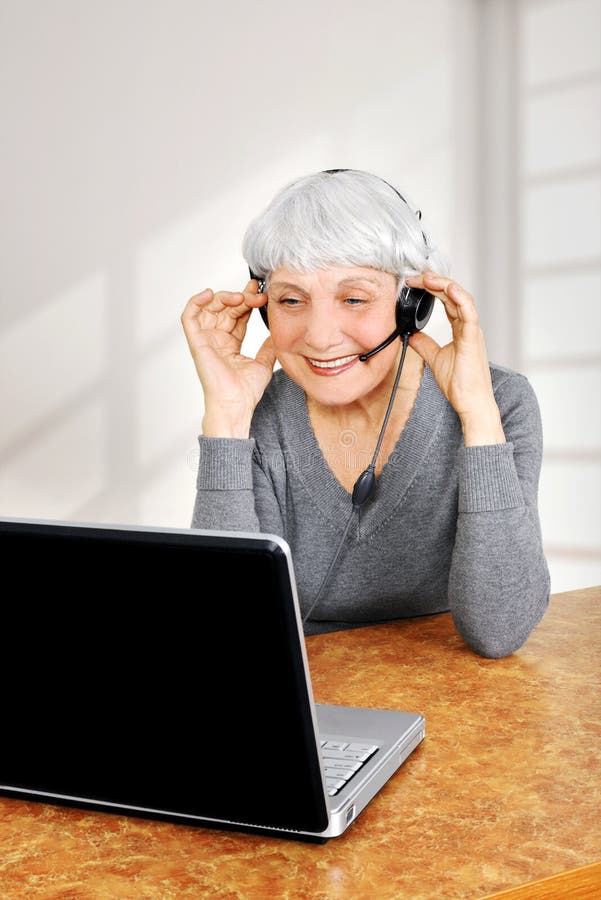 Elegant elderly senior woman using laptop computer communicates at home. Elegant elderly senior woman using laptop computer communicates at home