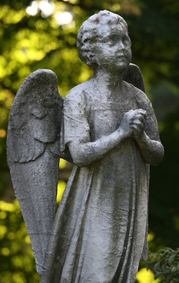 A stone statue of an angel in prayer. A stone statue of an angel in prayer