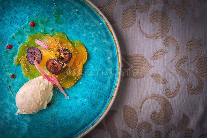 De exclusieve kaasmousse met gemarineerde okkernoten en gouden bieten diende op turkooise plaat, hoogste gastronomie stock foto's De exclusieve kaasmousse met gemarineerde okkernoten en gouden bieten diende op turkooise plaat, hoogste gastronomie stock foto's