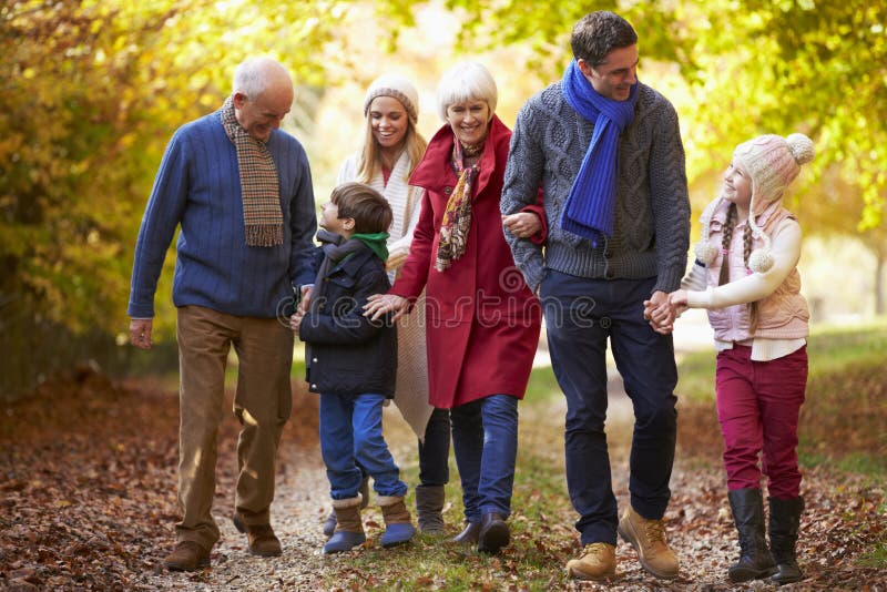 De Familie die van de Multlgeneratie langs Autumn Path lopen royalty-vrije stock afbeelding De Familie die van de Multlgeneratie langs Autumn Path lopen royalty-vrije stock afbeelding