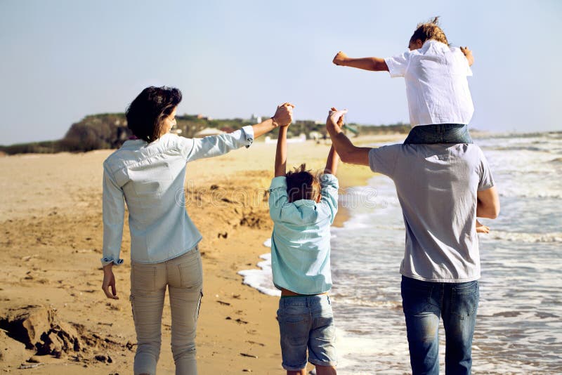 De familie genoot van lopend op het strand bij het overzees