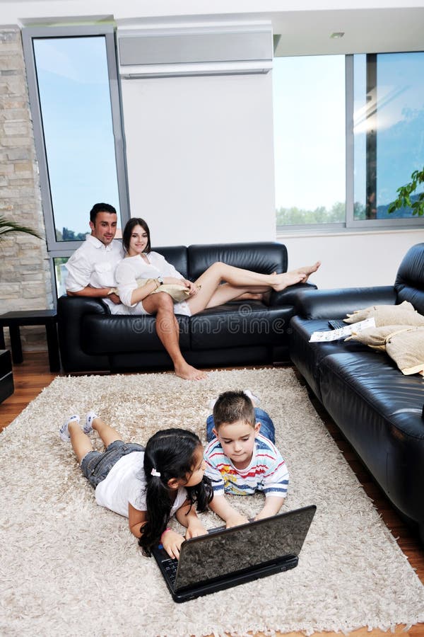 De familie heeft pret en thuis het werken aan laptop royalty-vrije stock foto's De familie heeft pret en thuis het werken aan laptop royalty-vrije stock foto's